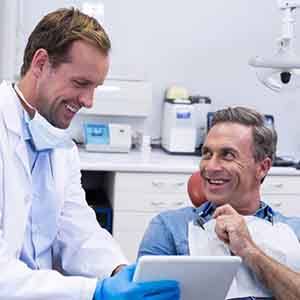 Dentist and patient smiling during consultation
