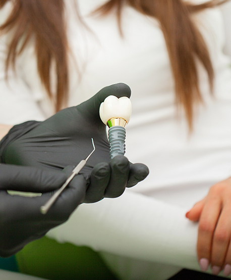 Dentist showing a patient a dental implant in Westbury