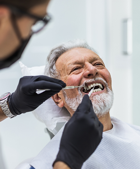 Dentist examining a senior patient's teeth