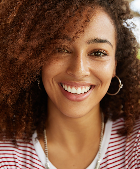 Smiling woman with curly dark hair and flawless teeth