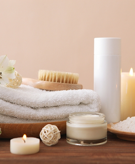 Folded towel next to spa like amenities like a bar of soap and a candle