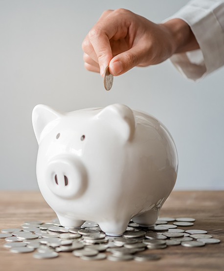 Hand placing a coin in a piggy bank