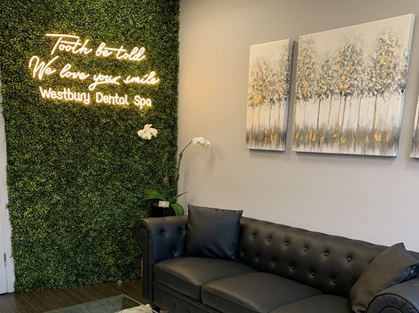 Comfortable looking black couch in waiting room of Westbury Dental Spa