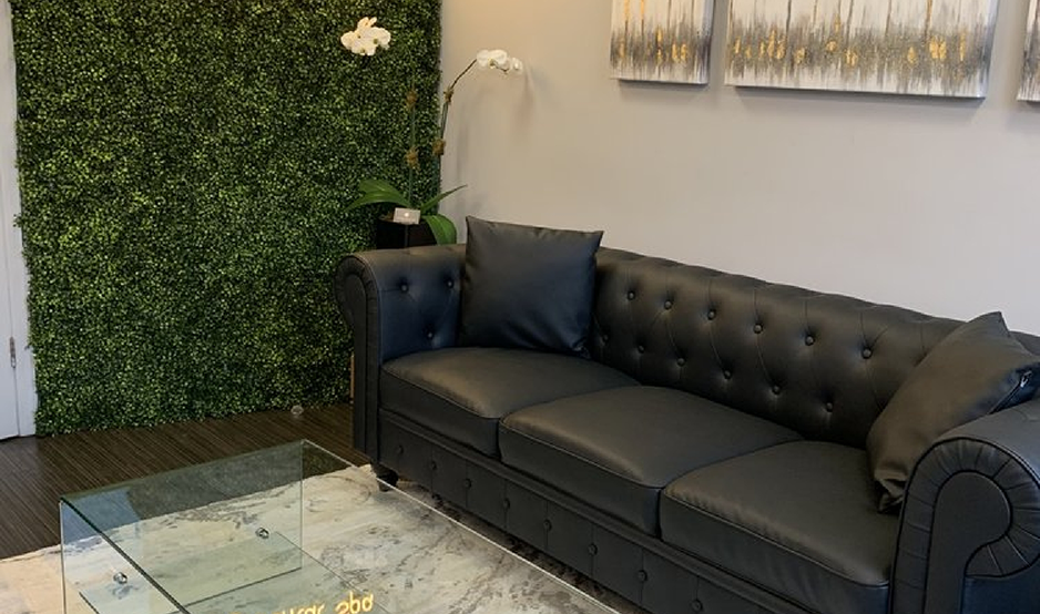 Comfortable looking black couch in the waiting room of dental office in Westbury