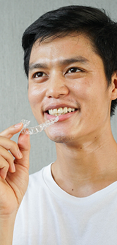 Man holding an Invisalign clear aligner