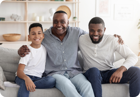 Three generations of men in a family smiling together on a couch