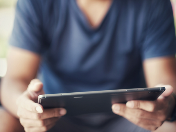 Person looking at a tablet while sitting on a couch