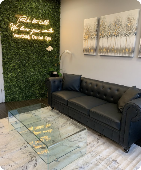 Comfortable looking black couch in waiting area of Westbury dental office